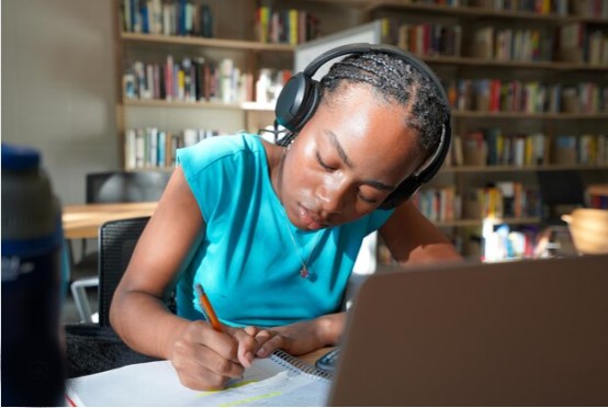 An African student listening to instrumental music while studying.